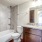 Large well lit bathroom with white accents 