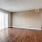Spacious and well lit living room with wood flooring, large windows and open access to the kitchen